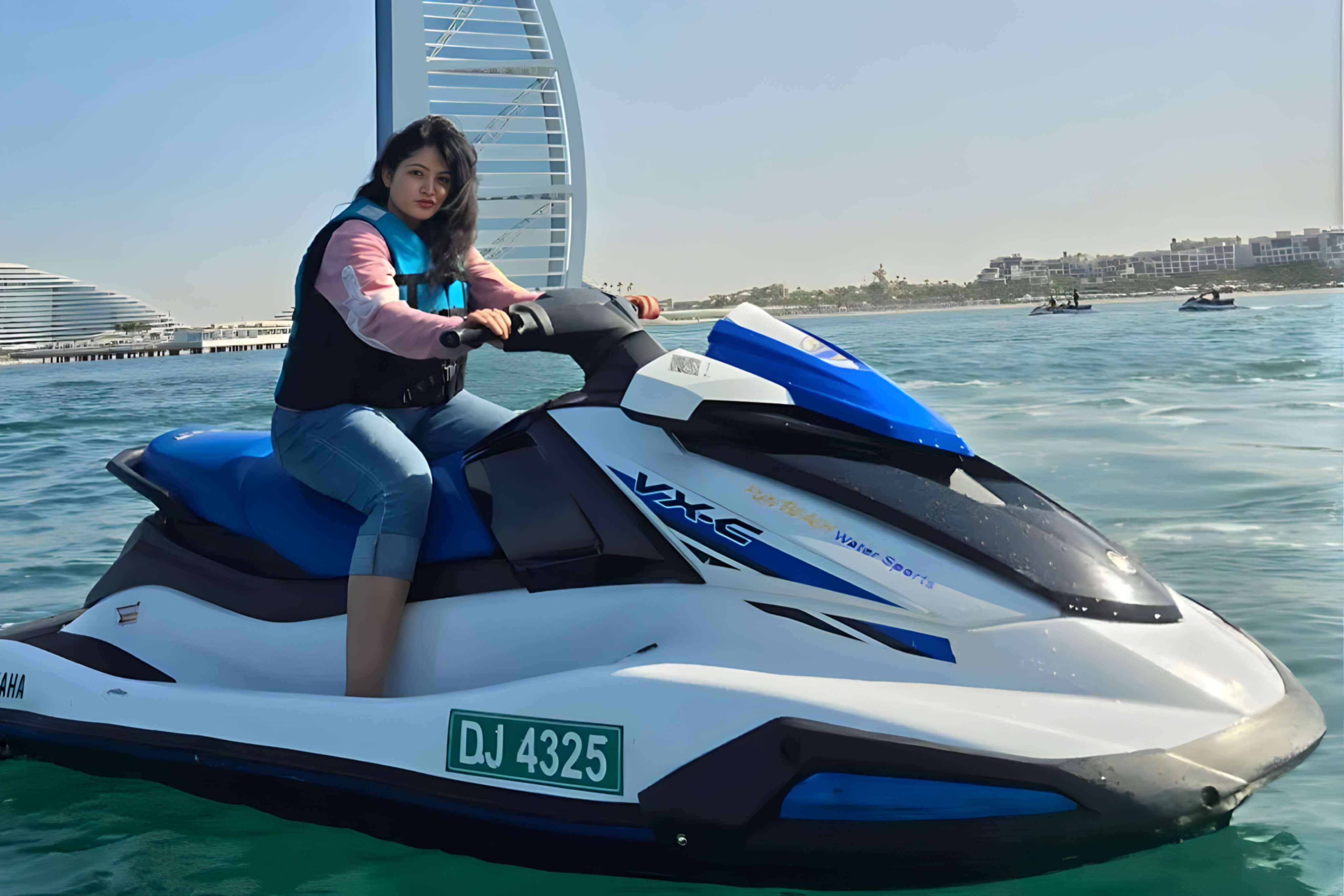Jet ski rider speeding across the Arabian Gulf in front of the Burj Al Arab in Dubai