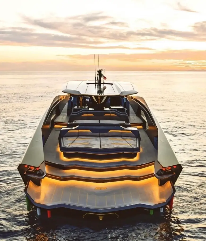 Tecnomar for Lamborghini 63 luxury yacht lit up at sunset on calm water