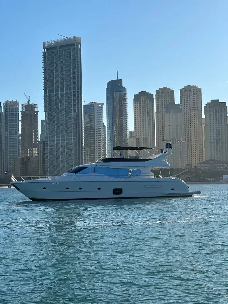 Luxury yacht cruising past the Dubai Marina skyline at golden hour